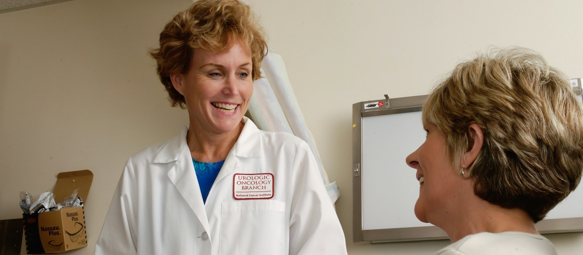 A family doctor smiling with an older patient in an exam room