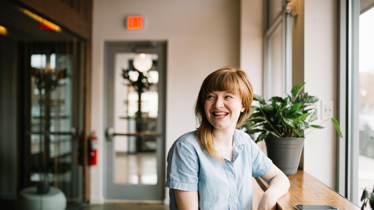 A smiling receptionist at a bright clinic front desk